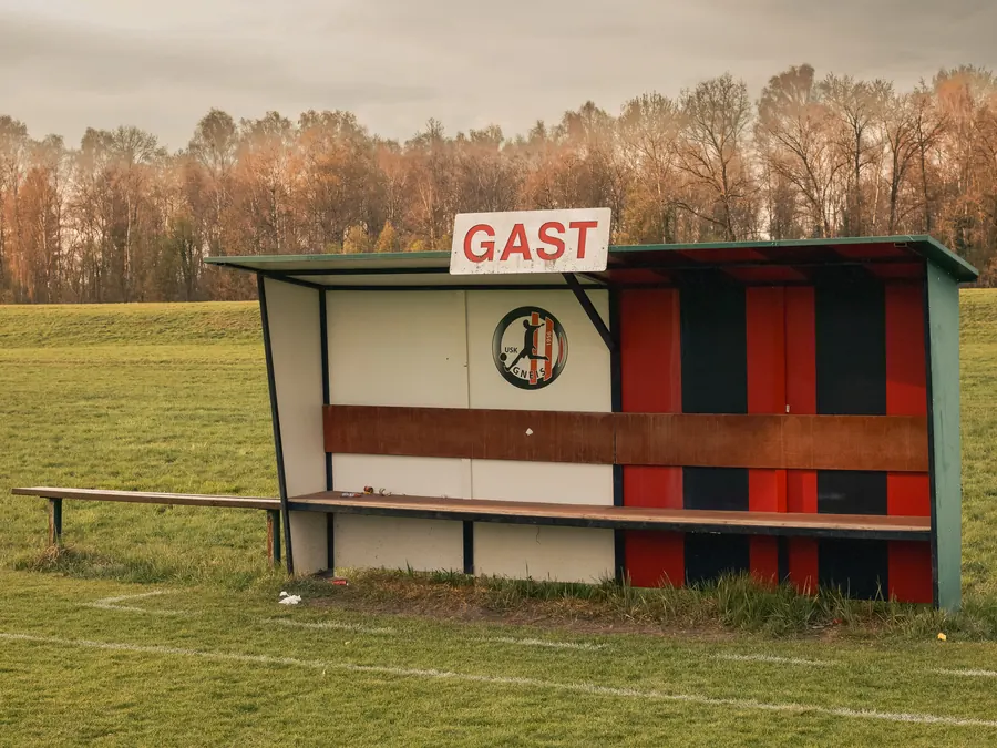 Away team dugout with the word GAST on a football pitch