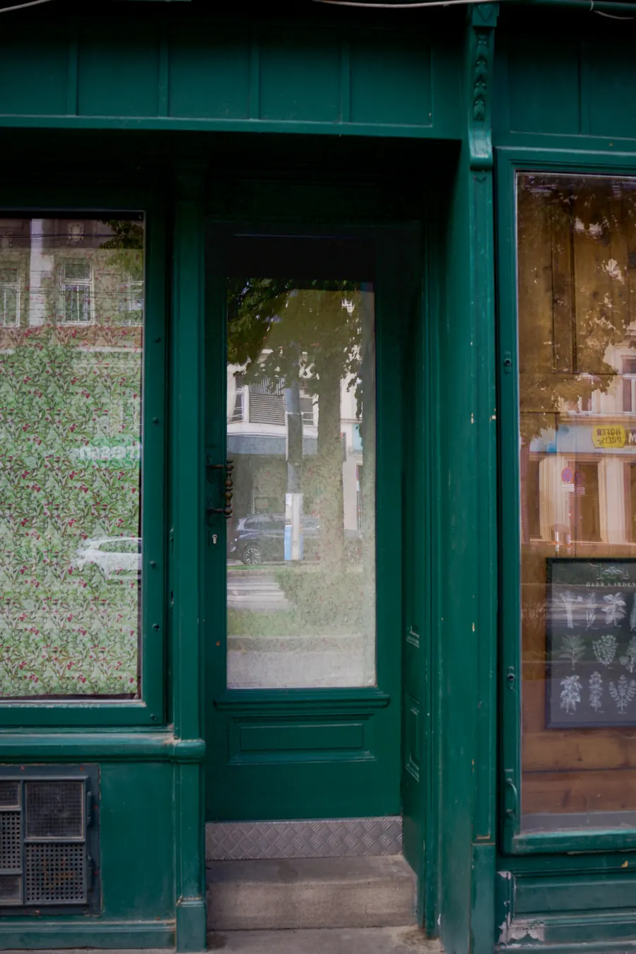Green wooden shopfront with a closed glass door, Vienna