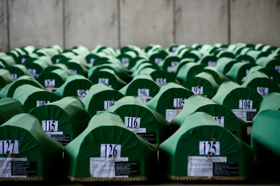 Rows of green-draped coffins with numbers before the burial, Potočari