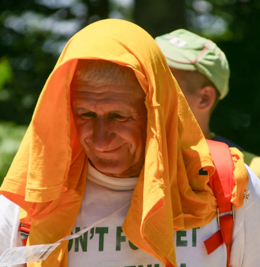 Marcher with an orange towel over his head against the heat